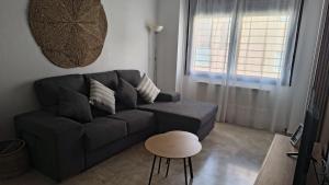 a living room with a black couch and a stool at Apartamento Bellarhouse II in Ciudad Real