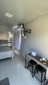 a bedroom with a bed and a table and chairs at Studio 02 Container Aeroporto in Florianópolis