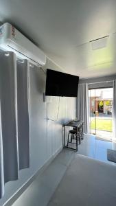 a living room with a table and a tv on the wall at Studio 02 Container Aeroporto in Florianópolis
