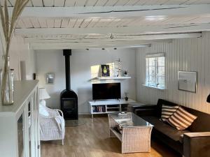 a living room with a couch and a stove at Seaside Cabin With Ocean View In Odsherred in Nyrup