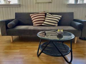 a living room with a couch and a glass table at Seaside Cabin With Ocean View In Odsherred in Nyrup
