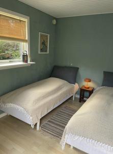 a bedroom with two beds next to a window at Seaside Cabin With Ocean View In Odsherred in Nyrup +9 photos