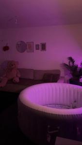 a living room with a purple room with a teddy bear at DouceNuits in Le Blanc-Mesnil