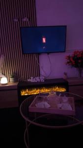 a room with a tv and a table with lights at DouceNuits in Le Blanc-Mesnil
