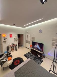 a large living room with a tv and a tub at استوديو مميز بأثاث مريح in Al Khobar
