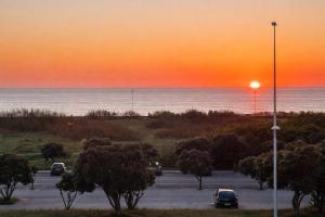 a parking lot with a sunset over the ocean at Vila Mar Guest House in Vila do Conde
