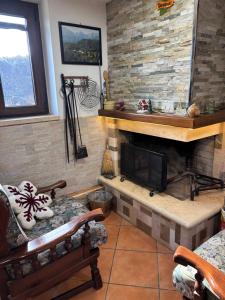 a living room with a fireplace and two chairs at Casa PerlAmbra Abruzzo in Casagreca
