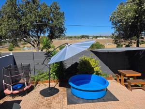 a patio with an umbrella and a table and chairs at 35 Amanda - Durbanville in Cape Town