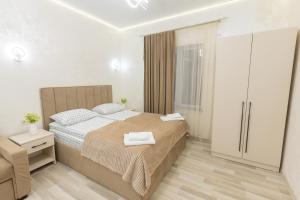 a bedroom with a large bed and a chair at Myasnikyan Suites in Gyumri