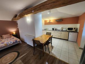 a room with a table and a bed and a kitchen at Studio du moulin de Montizeau in Saint-Maigrin