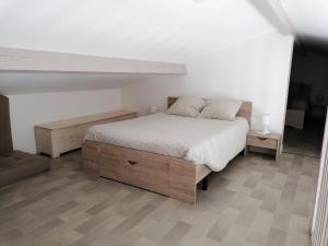a bedroom with a bed with a wooden bed frame at Maisonnette Bassin d'Arcachon in Mios