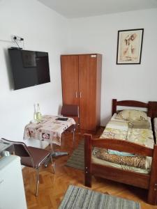 a room with a bed and a table and a tv at Tim in Kalna