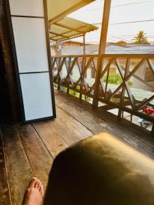 a person sitting on a balcony looking out at the ocean at Ruen Rinna home stays in Surin