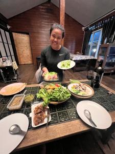 a woman sitting at a table with plates of food at Ruen Rinna home stays in Surin +12 photos