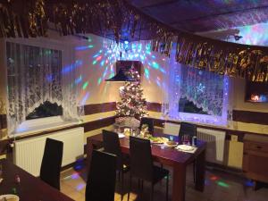 a dining room with a christmas tree on the wall at WELLNESS Penzion Triola in Kořenov +42 photos