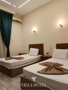 a hotel room with two beds and a window at Villa Downtown Hotel in Cairo