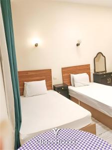 a room with two beds and a mirror at Villa Downtown Hotel in Cairo