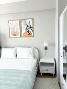 a white bedroom with a bed and two pictures on the wall at Sevez Homes in Gelibolu +32 photos