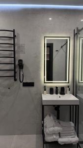 a bathroom with a sink and a mirror on a wall at Преміальні апартаменти на березі озера Молодості in Bukovel +9 photos