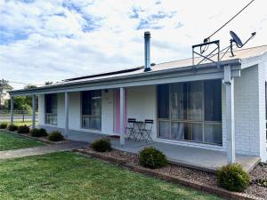 a white house with a table on the porch at Shell Shack in Tomakin +61 photos