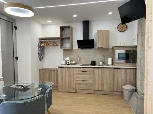 a kitchen with wooden cabinets and a glass table at El Doce Del Ferial in Solares