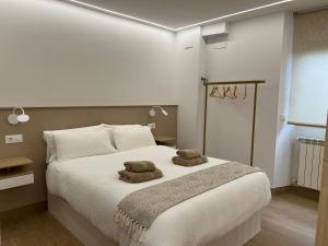 a bedroom with a bed with two towels on it at El Doce Del Ferial in Solares