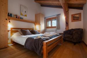 a bedroom with a large bed and a chair at Apt Clusettes 1-min walk to ski + parking & WiFi - Happy Rentals in Chamonix