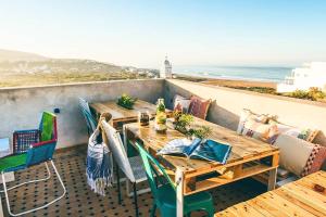 a table and chairs on a balcony with the ocean at Luxury Seafront Apartment in Agadir Vue Mer Taghazout Surf & Ocean View your Home place in Agadir