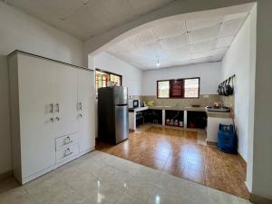a kitchen with a refrigerator in the middle of a room at Rose Apple Hostel in Ahangama