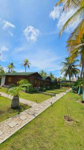 a resort with palm trees and a building at PalMar Ecolodge in Moñitos