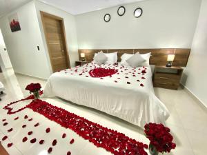 a bedroom with a bed covered in red roses at Suite Matrimonial 3plz con cocina y garage in Baños