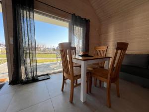 a table and two chairs in a room with a window at Domki BAMBINO in Sarbinowo
