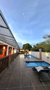 a resort with a swimming pool next to a building at Pousada Manancial in Itaúnas