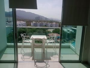 a table and chairs on a balcony with a view at Costa Azul Apto603 in Playa Dormida