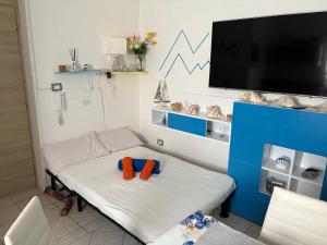 a room with a bed with a flat screen tv at La Stanza del Mare in Calasetta