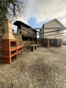 a building with a brick fireplace and a bench at Quinta do Passal - Country house in Parada de Ester