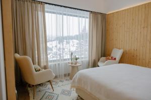 a hotel room with a bed and a large window at Vershok villa in Slavske +44 photos