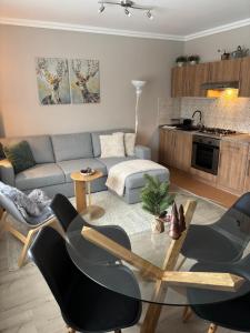 a living room with a couch and a table and chairs at Mátrai Kisház in Mátraszentimre