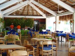 a restaurant with tables and chairs and people in the background at Costa Azul Apto603 in Playa Dormida