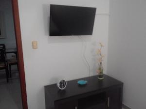 a black table with a television on a white wall at Costa Azul Apto603 in Playa Dormida