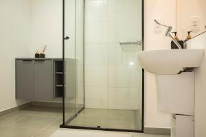 a bathroom with a glass shower and a sink at Essential comfort - Vila Mariana in São Paulo +31 photos