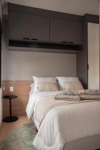 a bedroom with a large bed with white sheets at Essential comfort - Vila Mariana in São Paulo