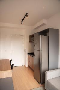 a kitchen with a stainless steel refrigerator and a table at Essential comfort - Vila Mariana in São Paulo
