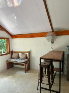 a room with a bench and a table with a lamp at Casa AllíS in Cóbano