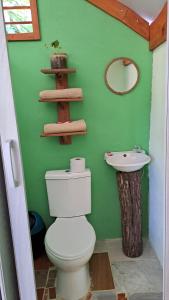a green bathroom with a toilet and a sink at Casa AllíS in Cóbano