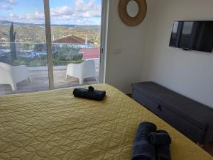 a bedroom with a bed and a large window at Casa Bravo in Querença +73 photos