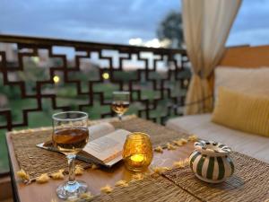 a table with two glasses of wine and a book at Stylish Apartment with Pool in Marrakech in Marrakesh