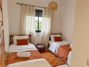 a room with two beds and a window at Stylish Apartment with Pool in Marrakech in Marrakesh +31 photos
