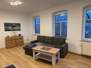 a living room with a couch and a table at Pension zum Kanal in Burg bei Magdeburg