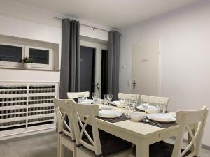 a white dining room table with white chairs and a white table and chairsktop at Ferienwohnung in Solingen Innenstadt in Solingen
